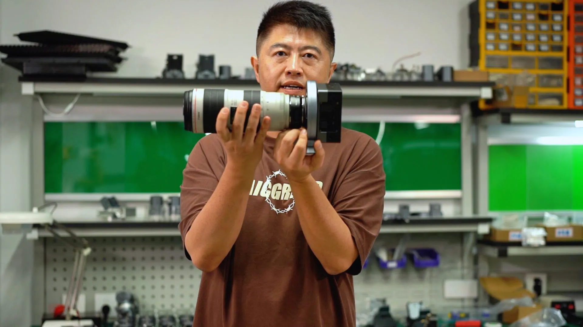 ArcBlue engineer holding the camera and telephoto optics assembly mounted to HALO CAA in the engineering lab.
