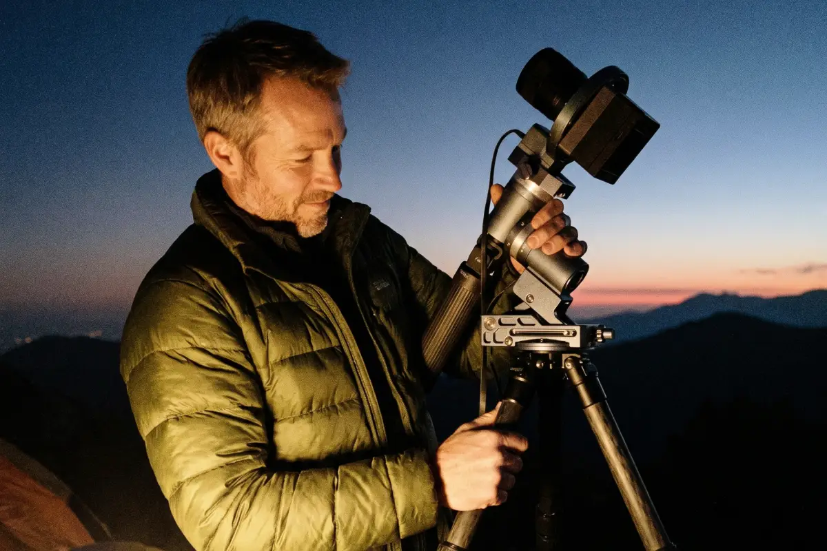 Astronomer setting up a compact deep-sky imaging system at dusk