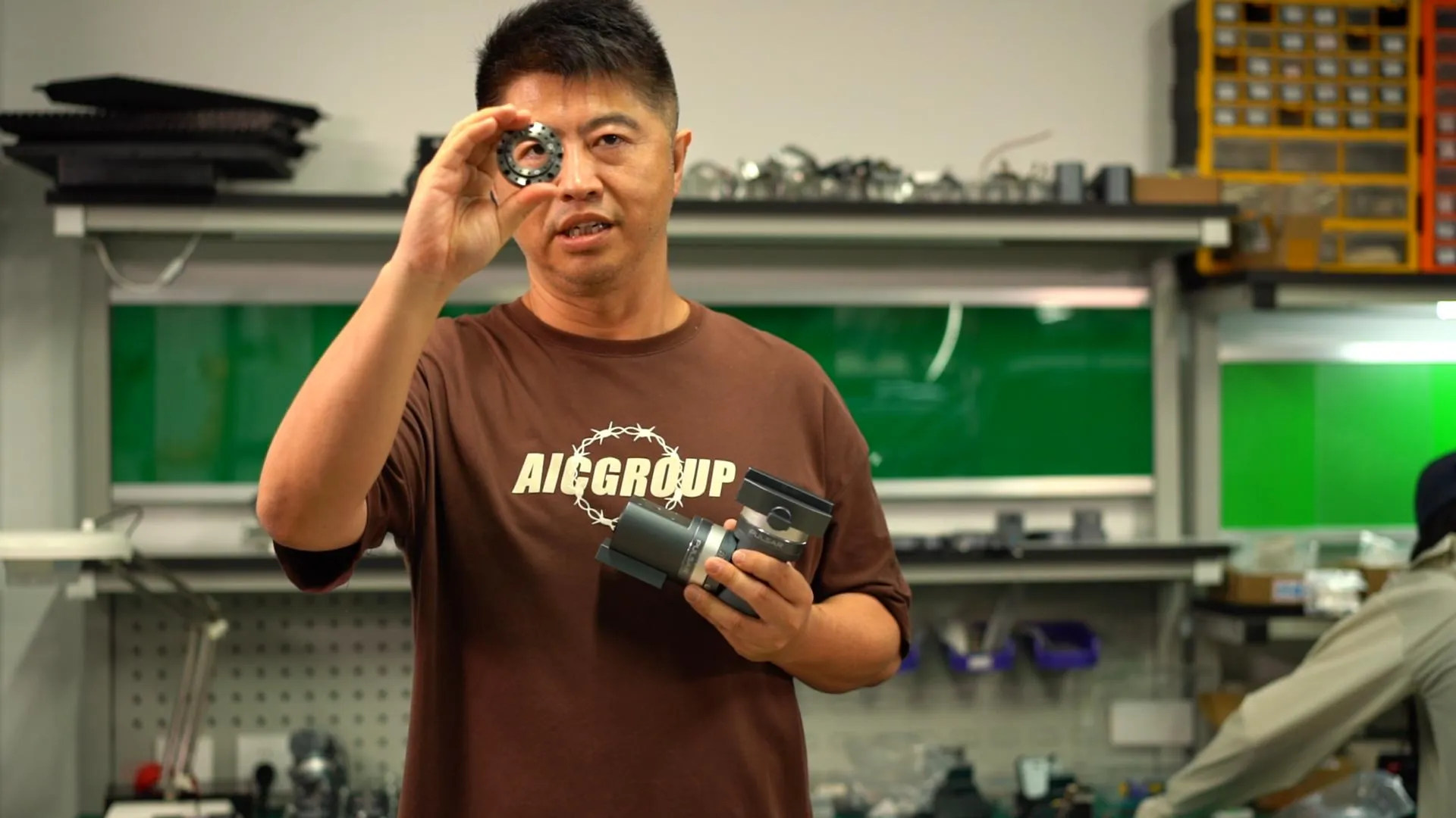 An ArcBlue engineer holding a compact harmonic drive component beside a Pulsar mount in the workshop.